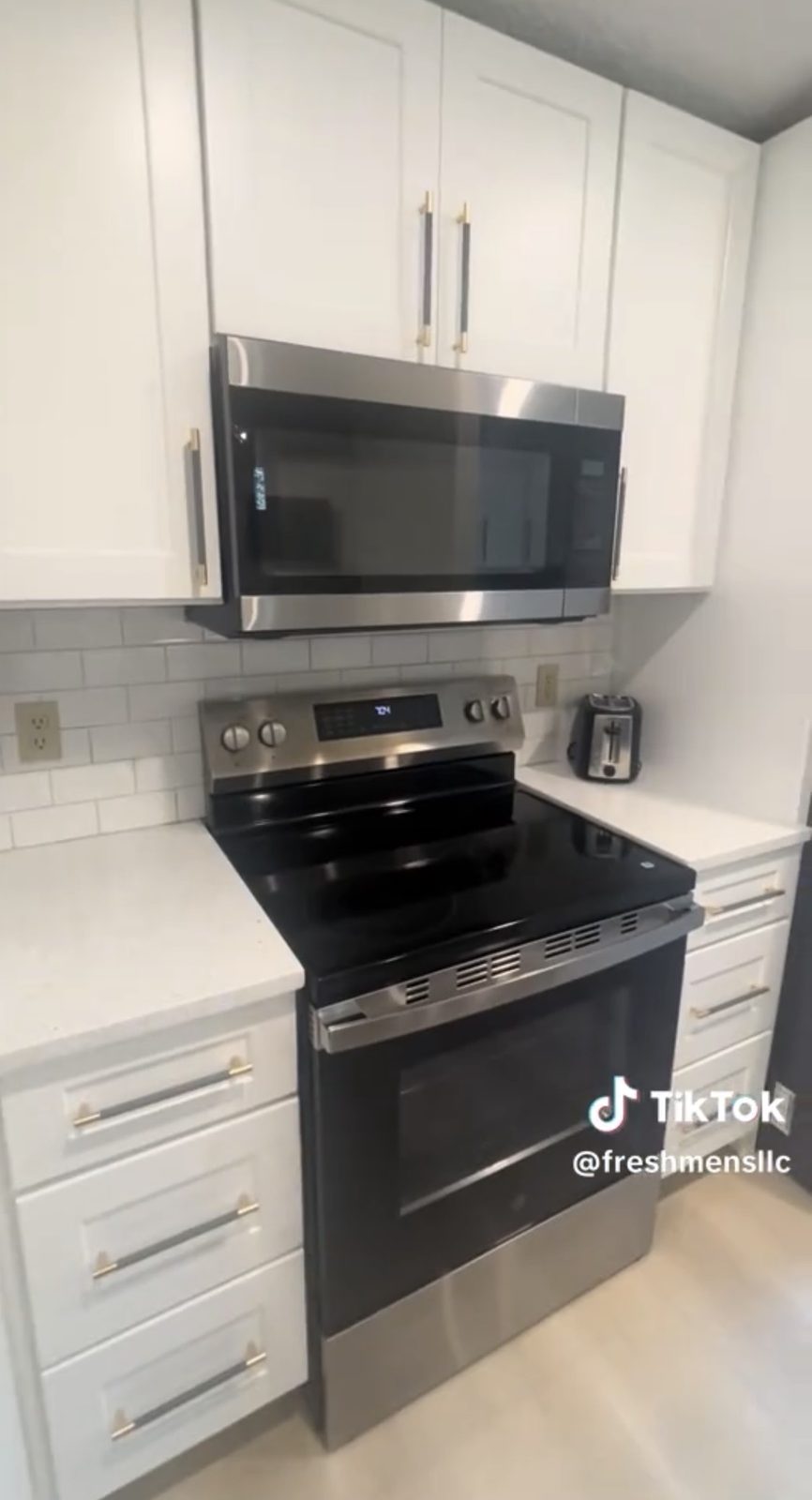 The kitchen renovated with white cabinetry, quartz counters and stainless appliances